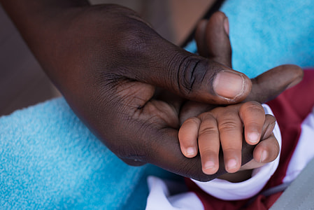 man holding baby's hand photo thumbnail