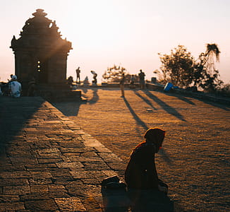 Person Sitting on Ground Outdoors thumbnail