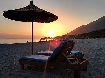 Brown Wooden Lounger on Seashore during Day Time thumbnail