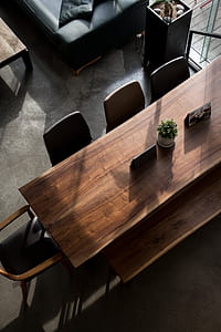 high-angle photo of brown wooden dining table with black leather chairs near black leather sofa thumbnail