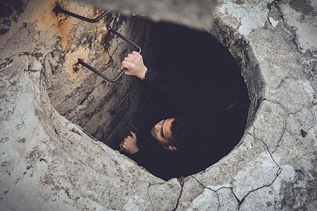 shallow focus photography of person climbing on wall-mount ladder towards surface during daytime thumbnail