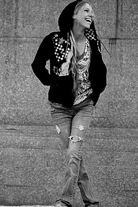 greyscale of woman in black zippered hoodie and ripped jeans thumbnail