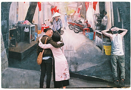man and woman standing near wall art during daytime thumbnail