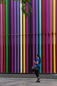 woman standing on multicolored wall thumbnail