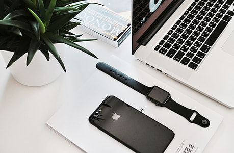 black Apple watch with black sport band and black iPhone 7 on white surface thumbnail