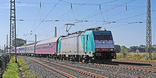 gray, pink, and blue train under blue sky thumbnail