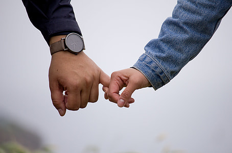 person holding pinky fingers in selective focus photography thumbnail