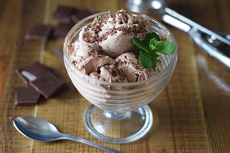 ice cream in glass bowl beside stainless steel spoon thumbnail