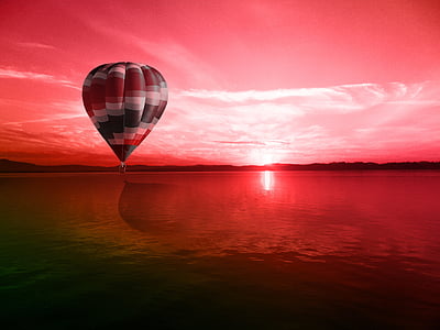 hot air balloon floating above water thumbnail