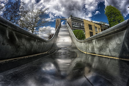 HDR photography of grey metal slide near trees thumbnail