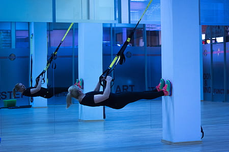 woman in black crew-neck t-shirt and black leggings hanging on white pillar thumbnail