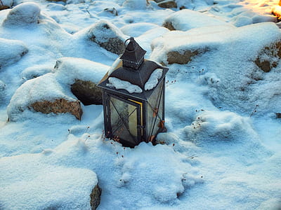 black metal candle lantern on snow field thumbnail