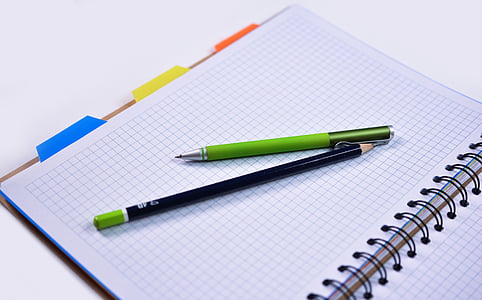 green click pen and black pencil on graphic notebook thumbnail
