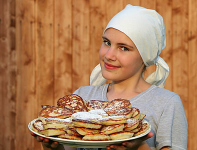 woman wearing gray scoop-neck t-shirt carrying pancake with powdered sugar on top thumbnail
