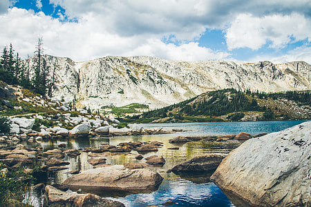 river surrounded by rocks near mountain ranges thumbnail