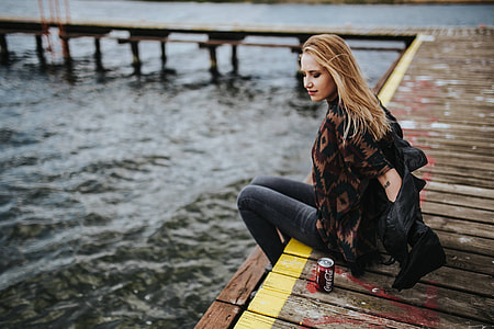 Beautiful blonde woman on a wooden pier by the lake thumbnail