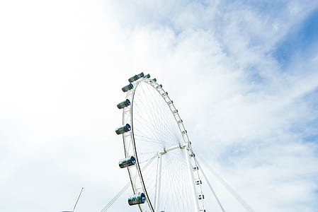ferris wheel under cloudy blue sky thumbnail