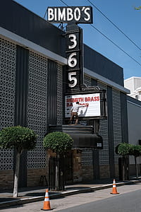 man standing on front store roof holding neno sign thumbnail
