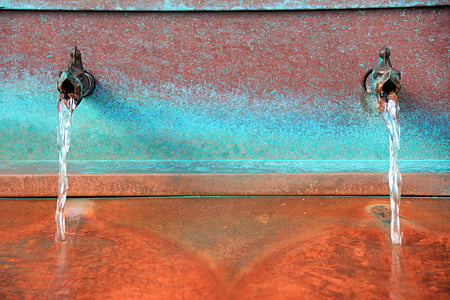 gray metal faucet pouring water on ground thumbnail