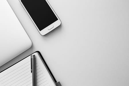 white smartphone beside pen on top of book thumbnail