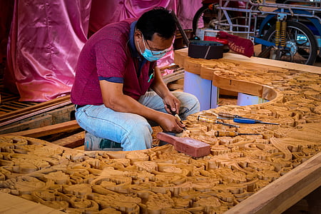 man carving in brown wooden table thumbnail