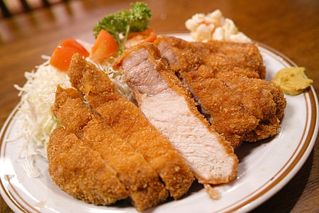 breaded chicken with white ceramic plate on brown table thumbnail