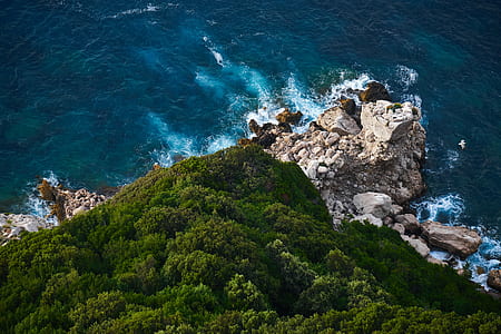 aerial photography of mountain surrounded by body of water thumbnail