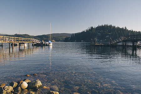 boat beside dock during daytime thumbnail