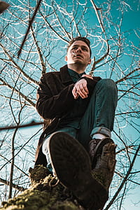 man sitting on tree branch smoking cigarette thumbnail