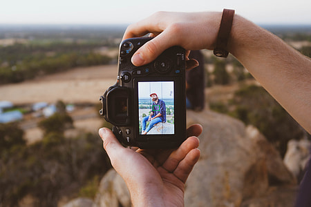 person holding black DSLR camera thumbnail