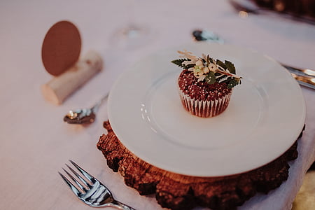 baked cupcake on white ceramic plate besides fork thumbnail
