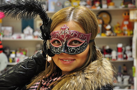 woman in black and pink masquerade mask near white shelf thumbnail