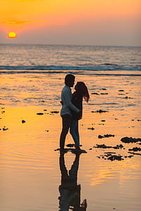Man and Woman Hugging by the Seashore during Sunset thumbnail