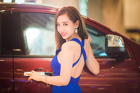 woman standing beside red vehicle while holding door handle thumbnail