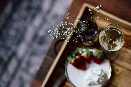 Strawberries with cream and glass of white wine on wooden tray thumbnail