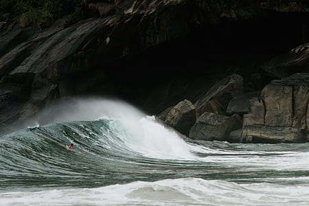 ocean wave hitting rocky shore thumbnail