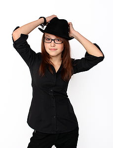 woman wearing black long-sleeved shirt standing near white wall while posing thumbnail
