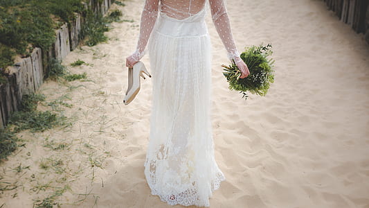 woman in wedding gown walking on sand thumbnail