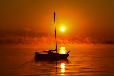 silhouette photo of boat on calm sea thumbnail
