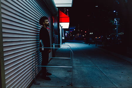 man in black shirt standing behind gray roller shutter thumbnail