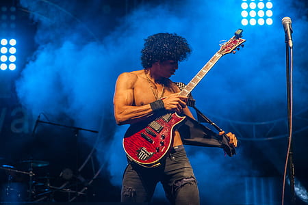 topless man playing electric guitar on stage thumbnail