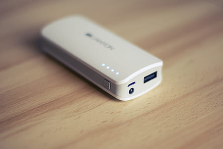 white power bank on beige wooden surface thumbnail