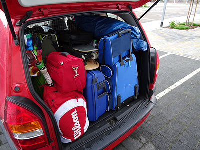 baggage and skateboard on vehicle's trunk parked on parking area thumbnail