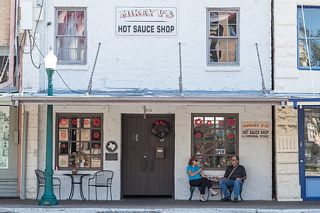 man and woman sitting together outside the Mikey V's hot sauce shop thumbnail