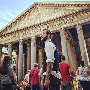 Man in Blue Waistcoat and White Dress Shirt Standing Near Magrippa Lf Costertivm Fecit Temple Behind Crowd of People thumbnail