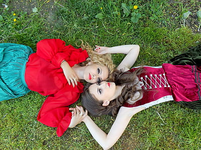 two women lying on green grass thumbnail