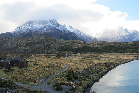 landscape photography of brown house near lake and mountain thumbnail