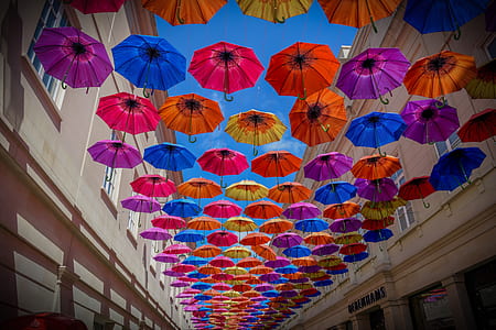 low-angle shot photography of umbrellas between buildings thumbnail