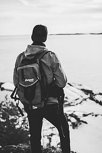 Grayscale Photo of Man Wearing Windsor and Backpack thumbnail