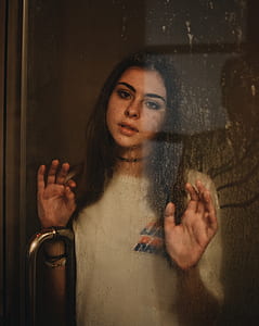 woman standing behind clear glass door thumbnail